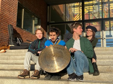 Fire personer og en cymbal på en trapp