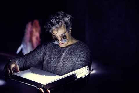 Hermann Sabado som leser i en stor bok i Engler i Amerika