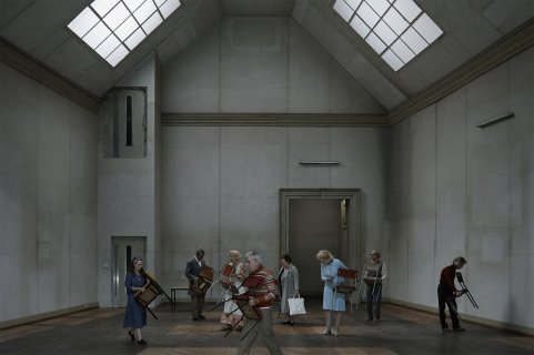 Folk som går rundt i et rom og bærer stoler