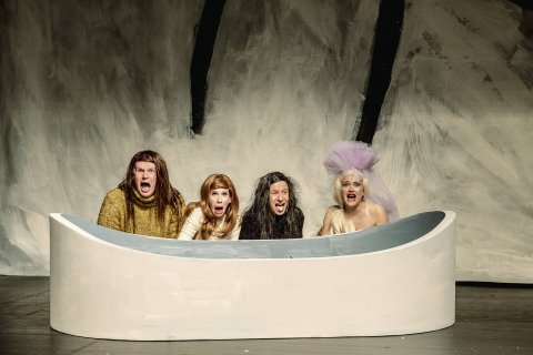 Fire personer sitter bak det som ser ut som et badekar