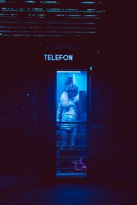 Kvinne står i telefonkiosk