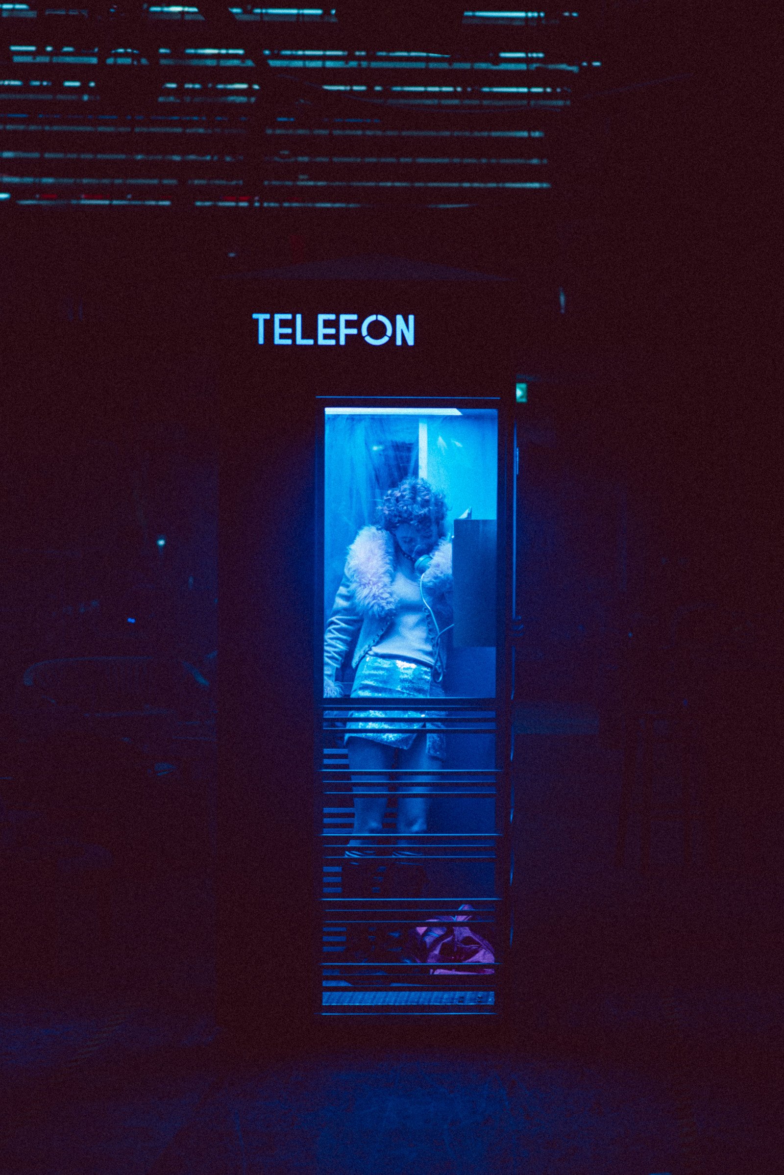 Kvinne står i telefonkiosk