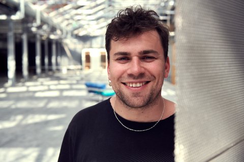 Portrett av smilende ung mann i hvit t-skjorte