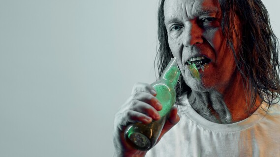 Portrett av mann som spiser en flaske