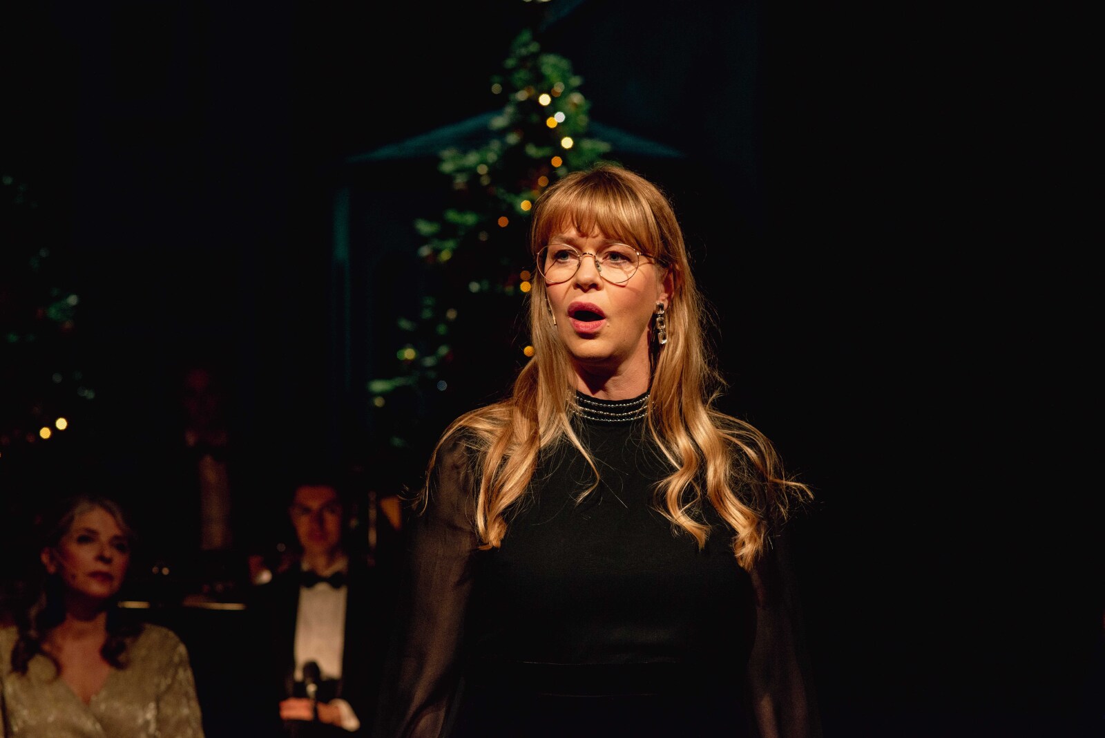Festkledde skuespillere på en julepyntet hovedscene