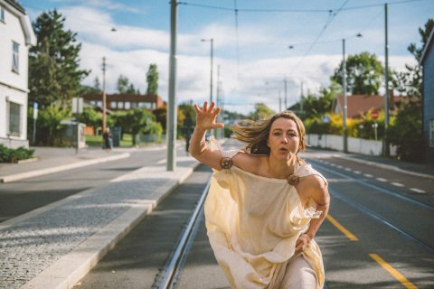 Kvinne i toga løper nedover gata