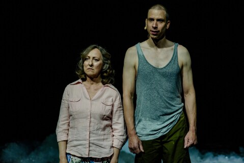 Mann og kvinne står ved siden av hverandre på mørk scene