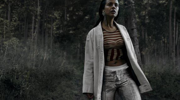 Kvinne står i en skog