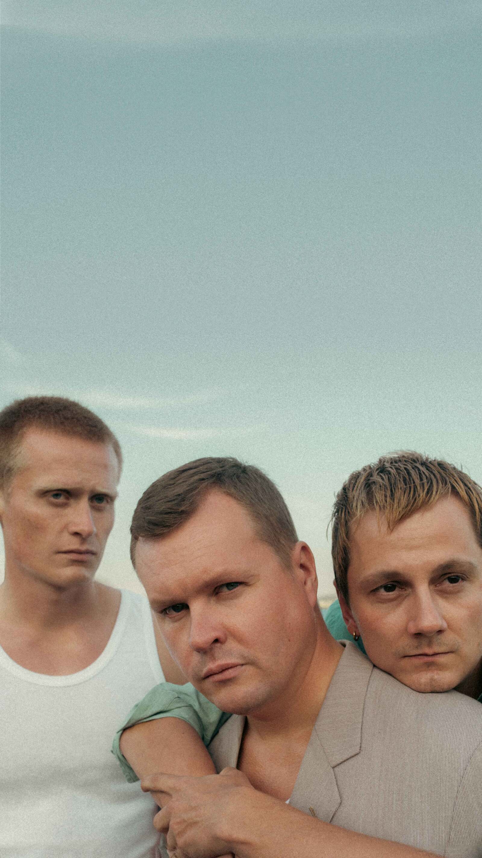 Tre unge menn på en strand