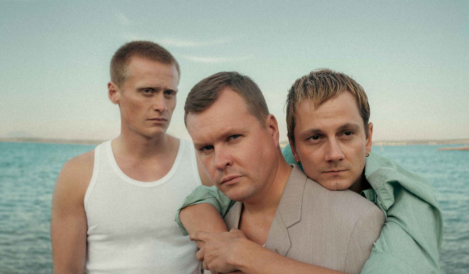 Tre unge menn på en strand