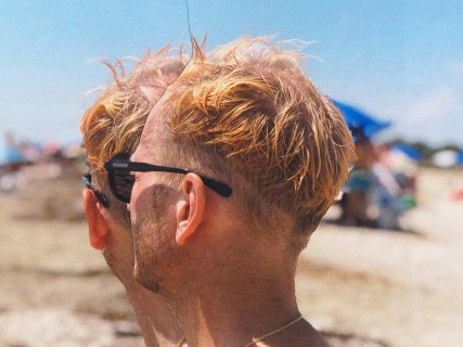 Hodene til to menn på en strand. De har solbriller på