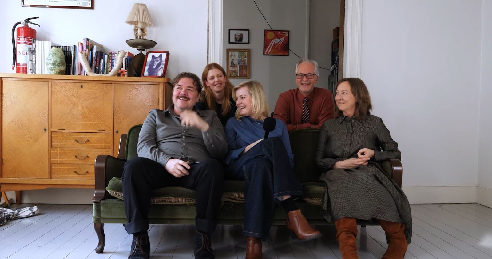 Fem personer i og bak en sofa i intervju