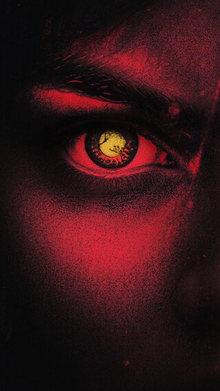 Mørkt nærbilde av høyre side av fjeset til en person med et gult øye