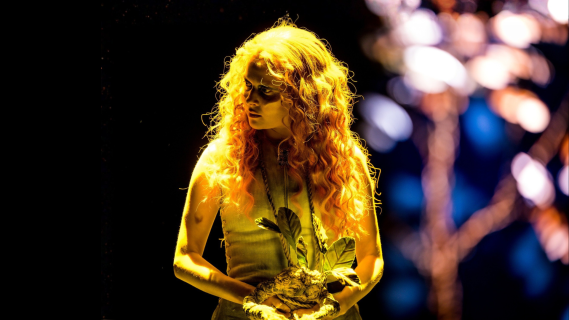 Mørkt nærbilde av høyre side av fjeset til en person med et gult øye