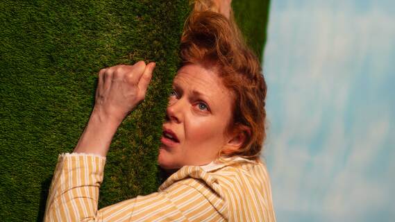 Kvinne som ligger og klamrer seg til kunstgress