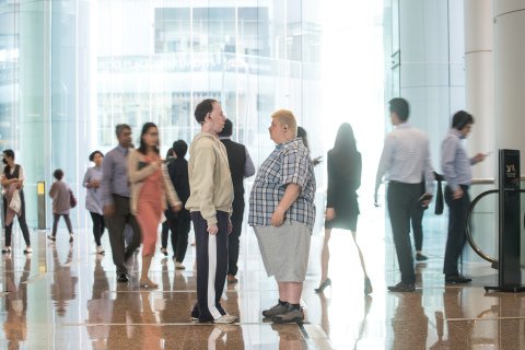 Two people facing each other in a large busy space